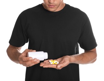Man with bottle of pills on white background, closeup. Doping concept