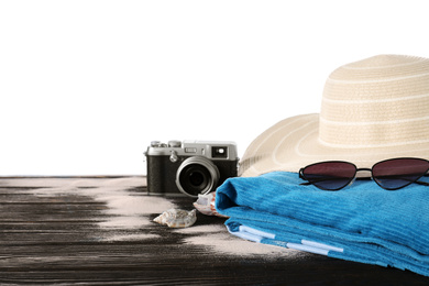 Photo of Different beach objects on black wooden table against white background