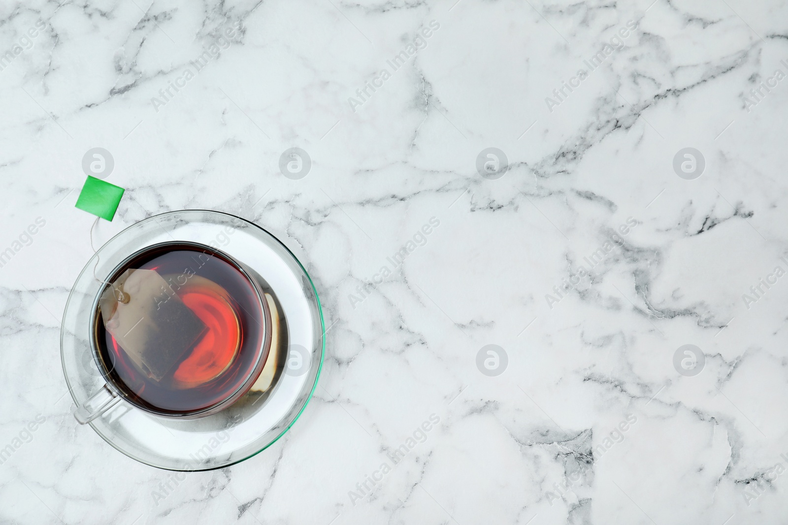 Photo of Cup of delicious hot tea and space for text on marble background, top view