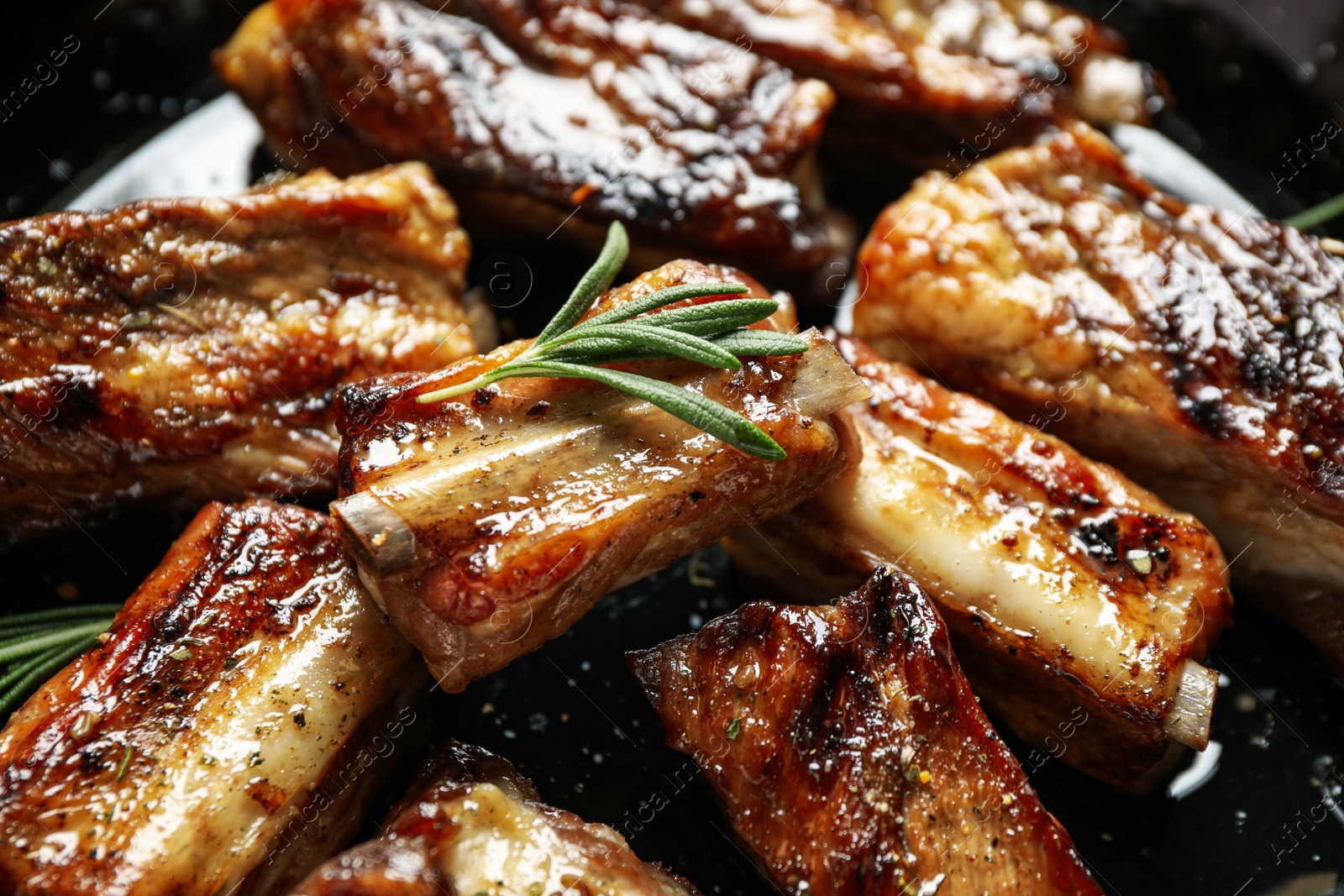 Photo of Delicious grilled ribs with rosemary, closeup view