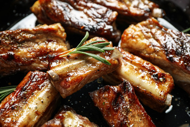 Photo of Delicious grilled ribs with rosemary, closeup view