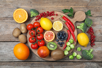 Photo of Different products rich in vitamin C on wooden table, flat lay