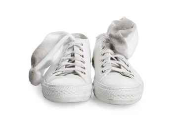 Photo of Dirty socks and sneakers on white background