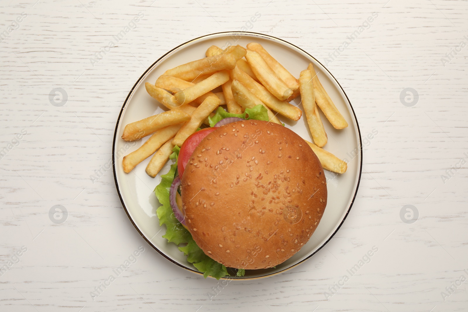 Photo of French fries and tasty burger on white wooden table, top view