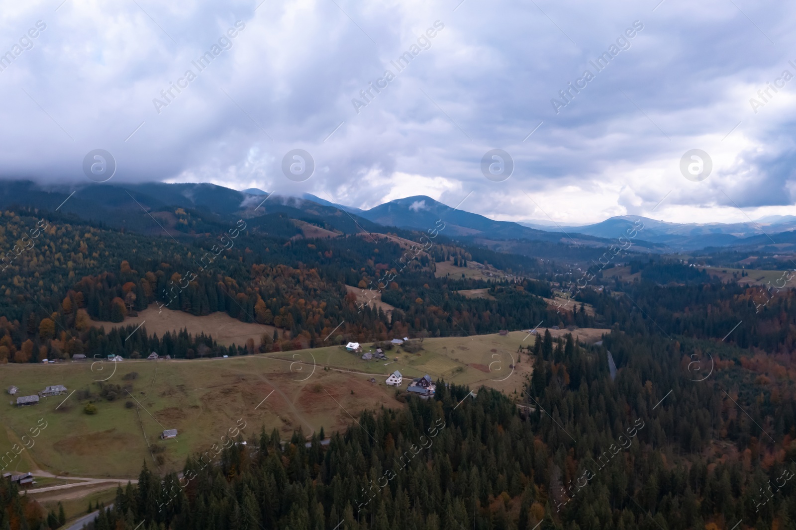 Image of Aerial view of beautiful forest and mountain village on autumn day