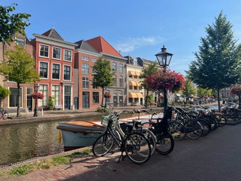 Photo of Beautiful view of parking with bicycles and plants near canal on city street