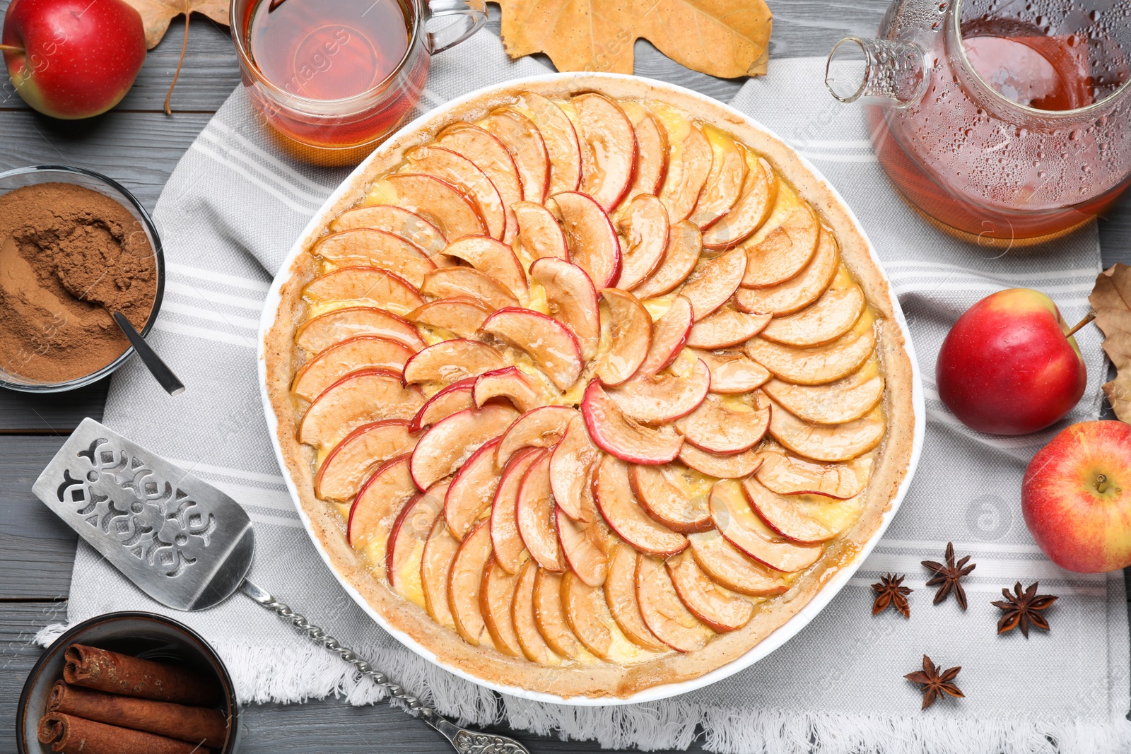 Photo of Flat lay composition with tasty apple pie on grey wooden table