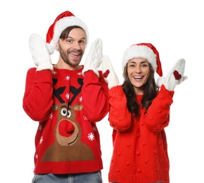 Photo of Young couple in Christmas sweaters and hats on white background