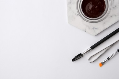Photo of Flat lay composition with eyebrow henna and professional tools on white background, space for text