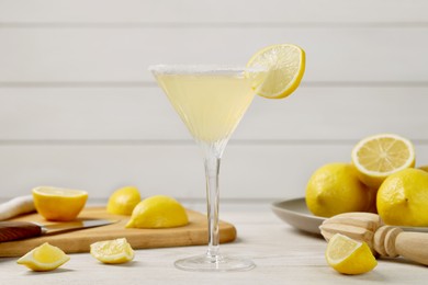 Photo of Lemon Martini cocktail and fresh fruits on white wooden table