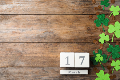 Flat lay composition with block calendar on wooden background, space for text. St. Patrick's Day celebration