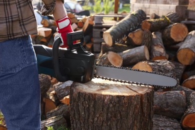 Man with modern saw outdoors, closeup view