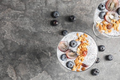 Photo of Tasty chia seed pudding with granola served on table, flat lay. Space for text