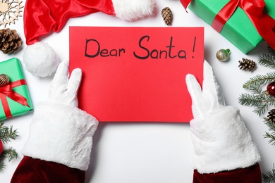 Santa Claus with letter and Christmas decor on white background, top view