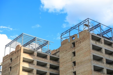 Photo of Unfinished building against blue sky. Construction safety rules