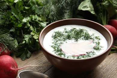 Delicious cold summer soup with kefir served on wooden table