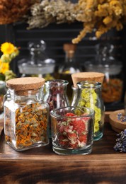 Photo of Different dry herbs and flowers on wooden table