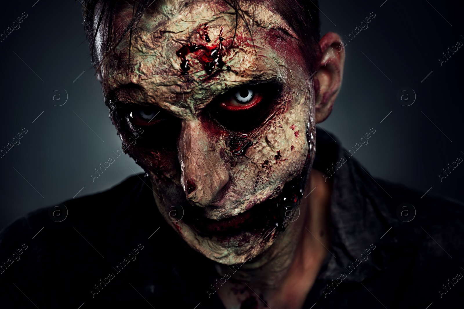 Photo of Scary zombie on dark background, closeup. Halloween monster