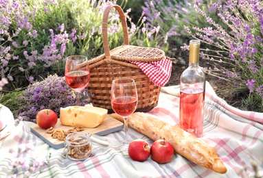 Photo of Set for picnic on blanket in lavender field
