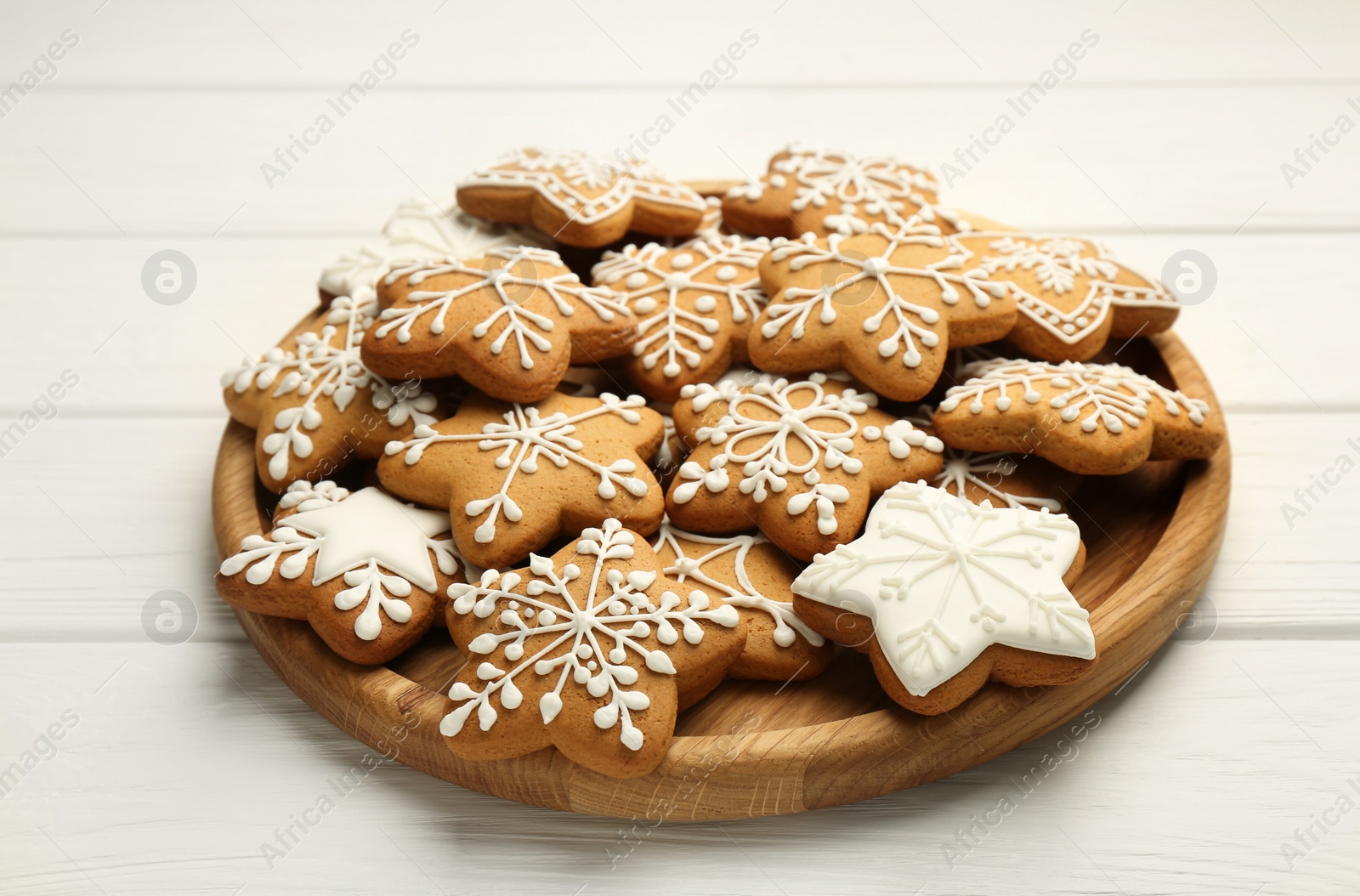 Photo of Tasty Christmas cookies with icing on white wooden table