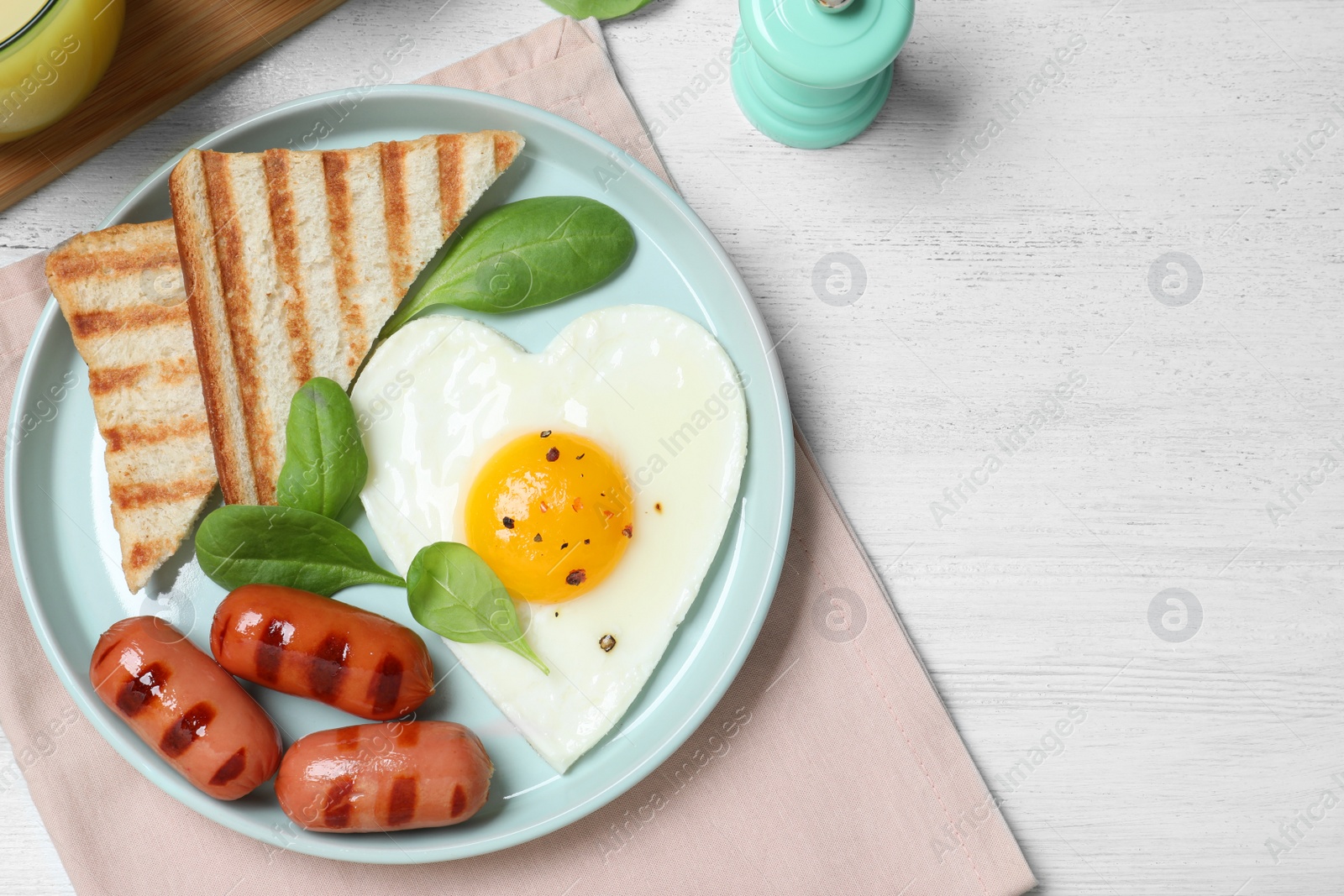 Photo of Tasty breakfast with heart shaped fried egg served on white wooden table, flat lay. Space for text