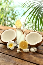 Composition with glass of coconut water and lemon on wooden table