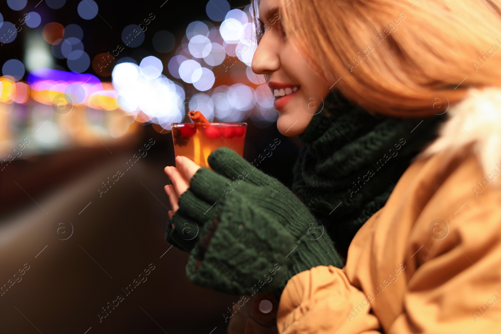 Photo of Happy woman with tasty mulled wine at winter fair