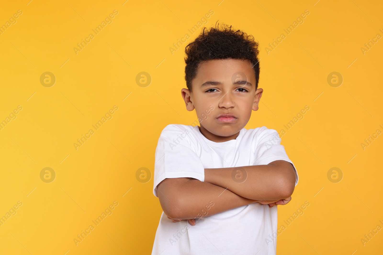 Photo of Emotional African-American boy on yellow background. Space for text