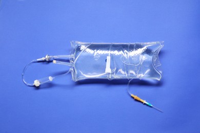 Photo of IV infusion set on blue background, top view