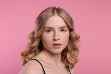 Photo of Portrait of beautiful woman with blonde hair on pink background