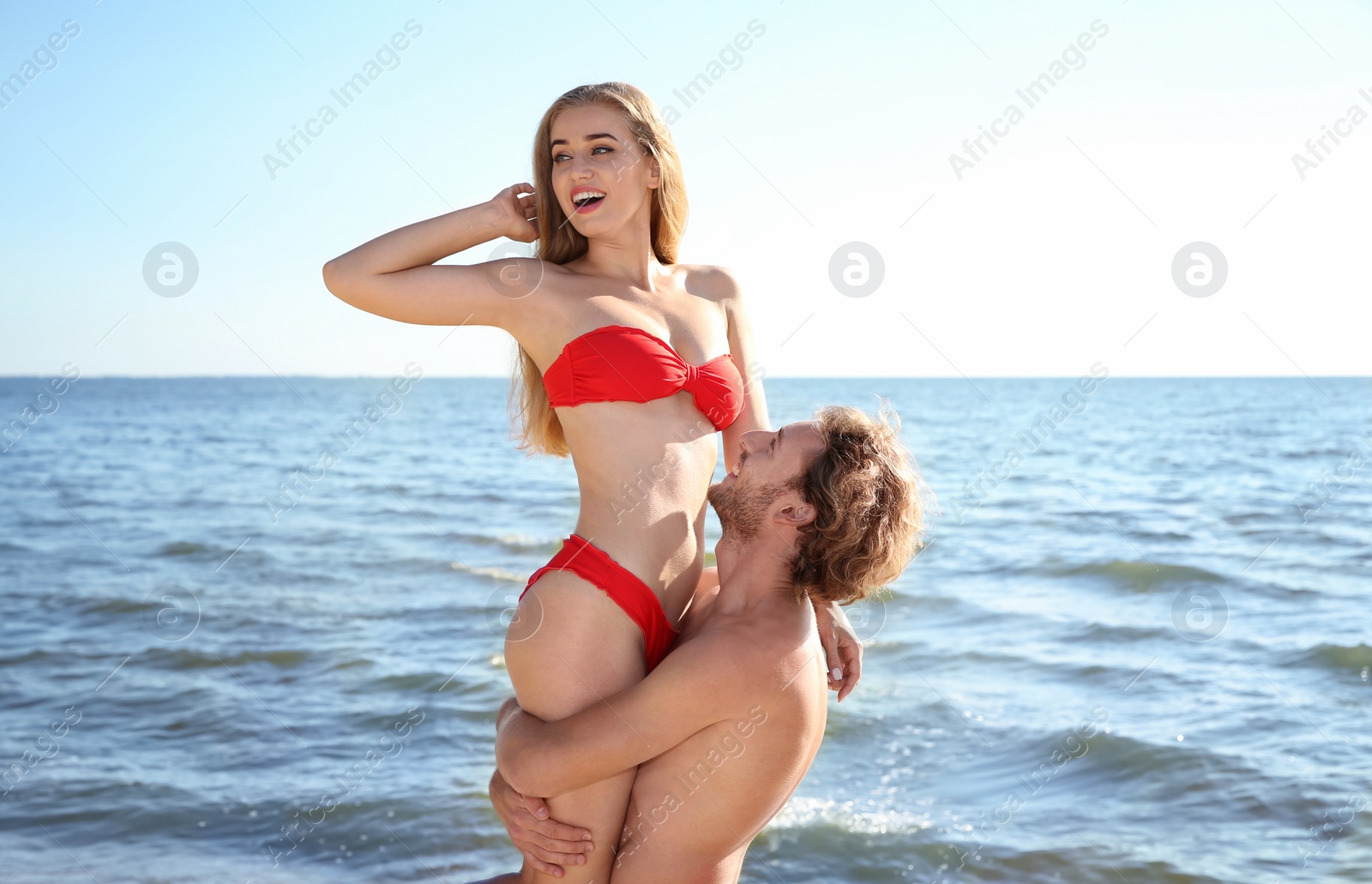 Photo of Happy young couple in beachwear having fun on seashore