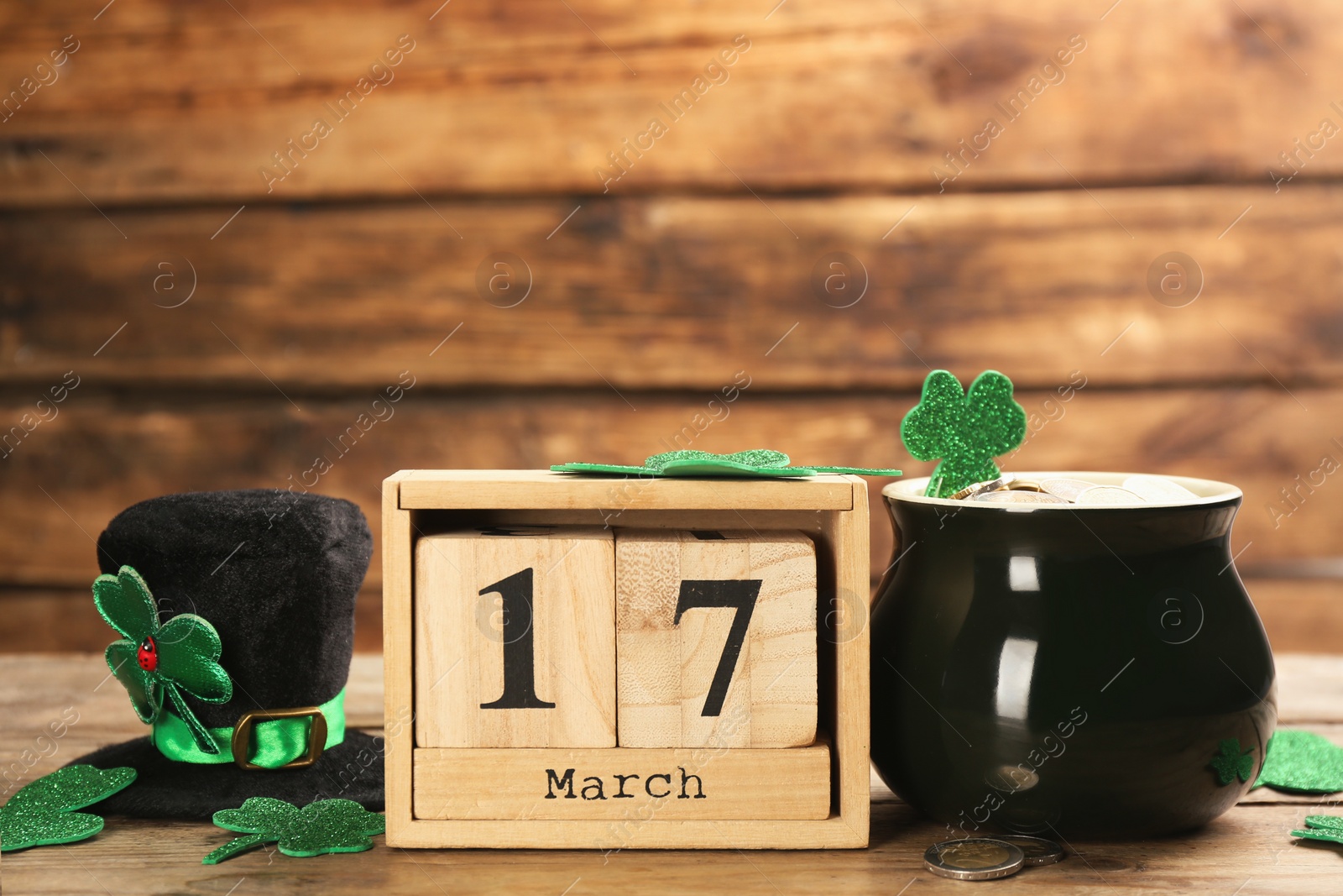 Photo of Leprechaun's hat, block calendar and St. Patrick's day decor on wooden table