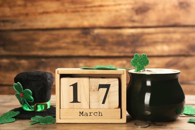 Leprechaun's hat, block calendar and St. Patrick's day decor on wooden table