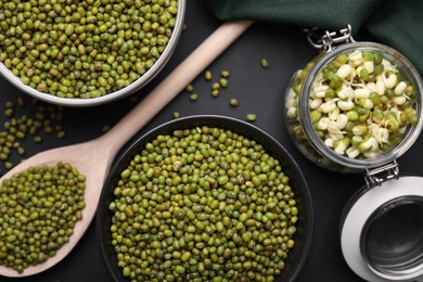 Photo of Different dishware with green mung beans on black background, flat lay