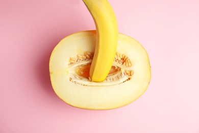 Flat lay composition with fresh banana and melon on pink background. Sex concept
