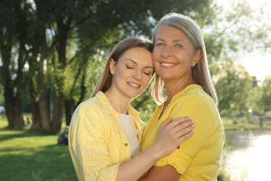 Photo of Family portrait of happy mother and daughter spending time together in park on sunny day
