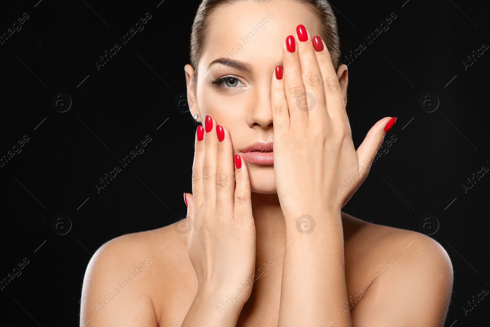 Photo of Beautiful young woman with bright manicure on black background. Nail polish trends