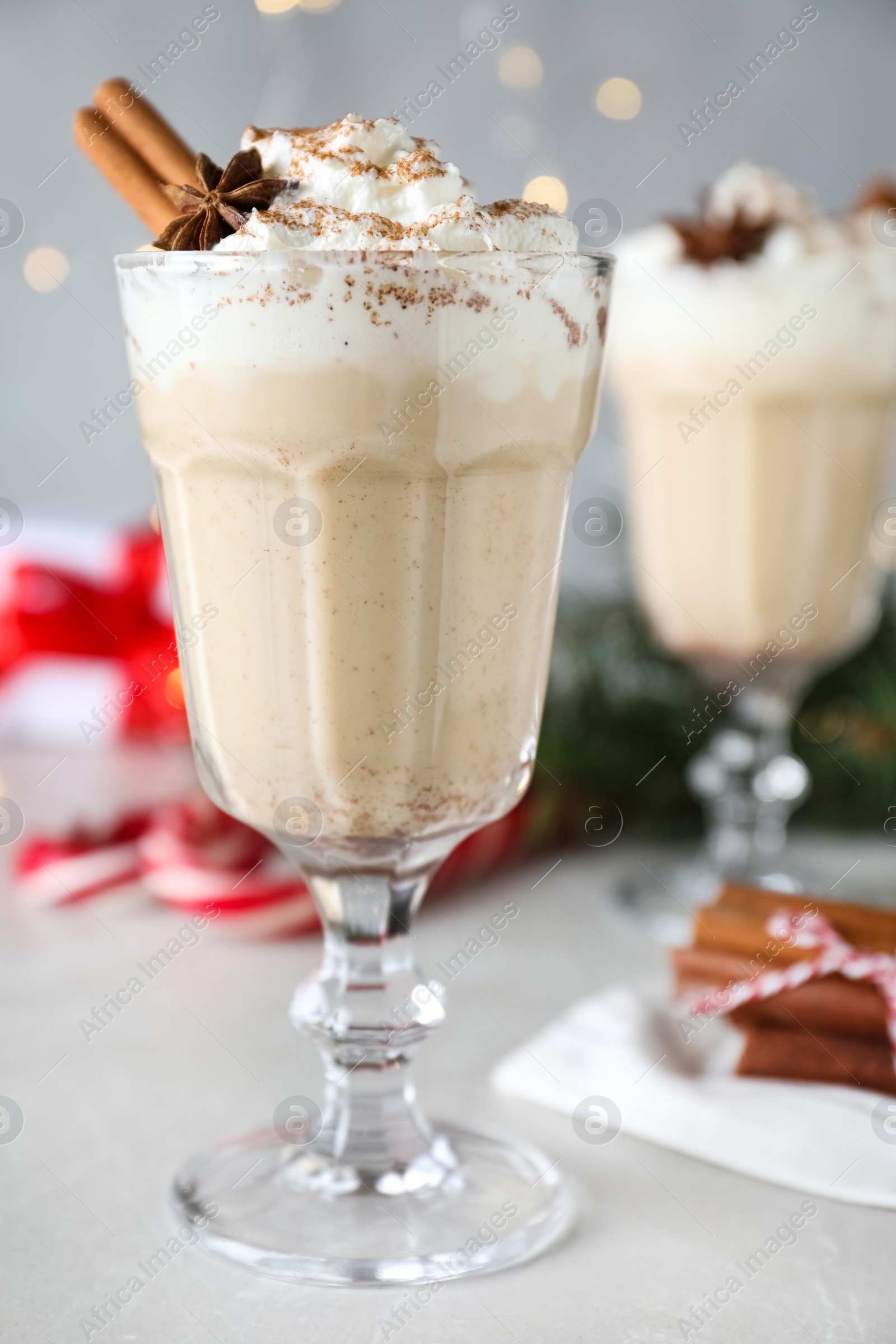 Photo of Delicious Christmas cocktail with liqueur on white table, closeup