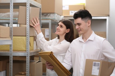 Young post office employees working in warehouse