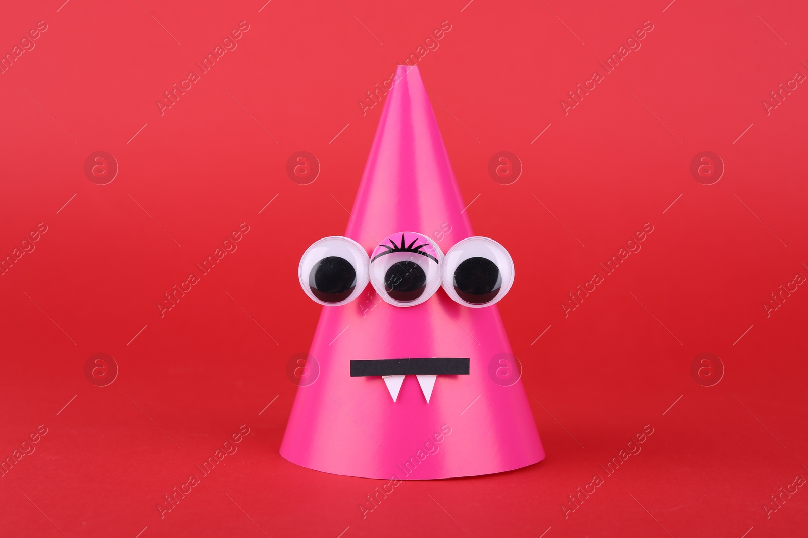 Photo of Spooky paper Halloween monster on red background