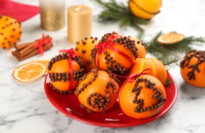 Photo of Pomander balls made of fresh tangerines and cloves white marble table