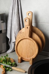 Photo of Wooden cutting boards, knife and parsley on light grey countertop in kitchen