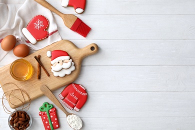 Photo of Delicious Christmas cookies and ingredients on white wooden table, flat lay with space for text