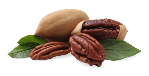 Photo of Many tasty pecan nuts with green leaves isolated on white