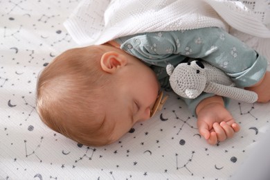 Photo of Adorable baby with toy peacefully sleeping in bed