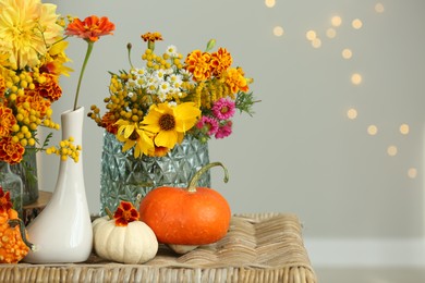 Photo of Beautiful autumn composition with pumpkins and flowers on wicker table, space for text