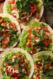 Delicious tacos with vegetables and meat on table, flat lay