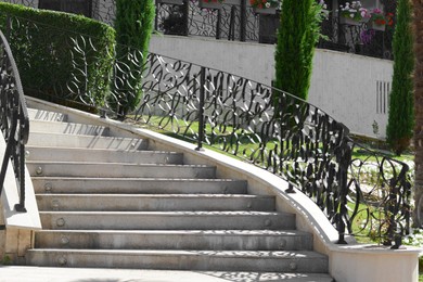 Photo of Staircase with beautiful ornate handrails outdoors on sunny day