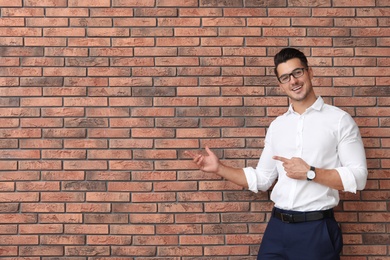 Photo of Portrait of handsome young man and space for text on brick wall background