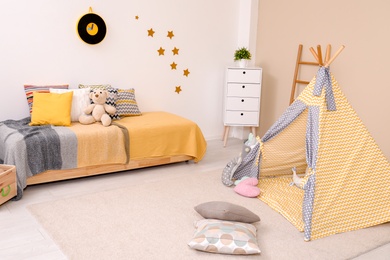 Cozy child room interior with bed, play tent and modern decor elements